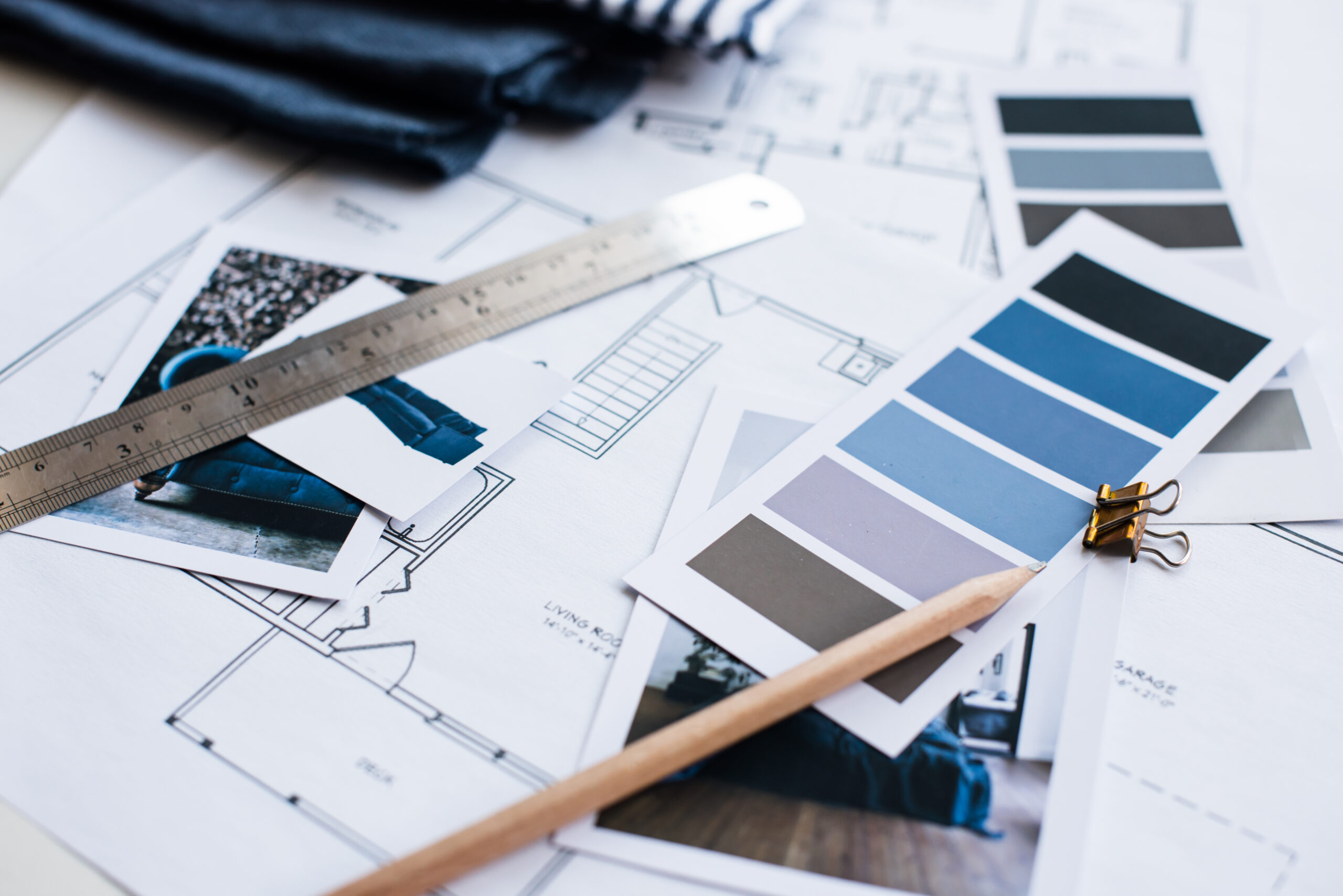 Interior designer's working table, an architectural plan of the house, a color palette, furniture and fabric samples in blue color. Drawings and plans for house decoration.