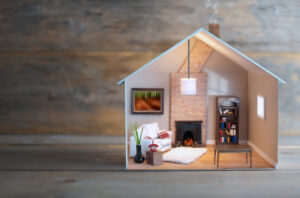 Model house with lights on inside over wood with space